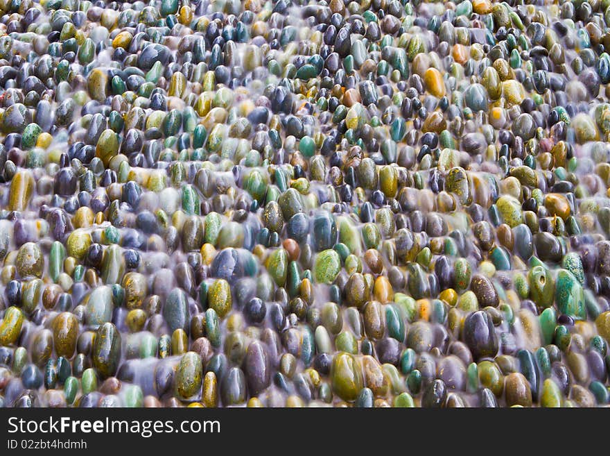 Water running over colourful pebbles