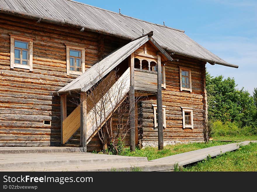 Traditional russian rural house at midday with green grass