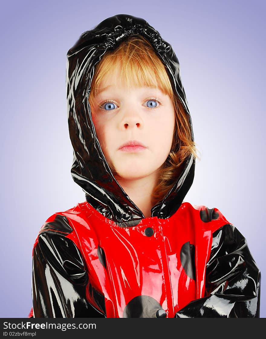 Studio shot child portrait with funny face in  red raincoat isolated on the gradient  background. Studio shot child portrait with funny face in  red raincoat isolated on the gradient  background.