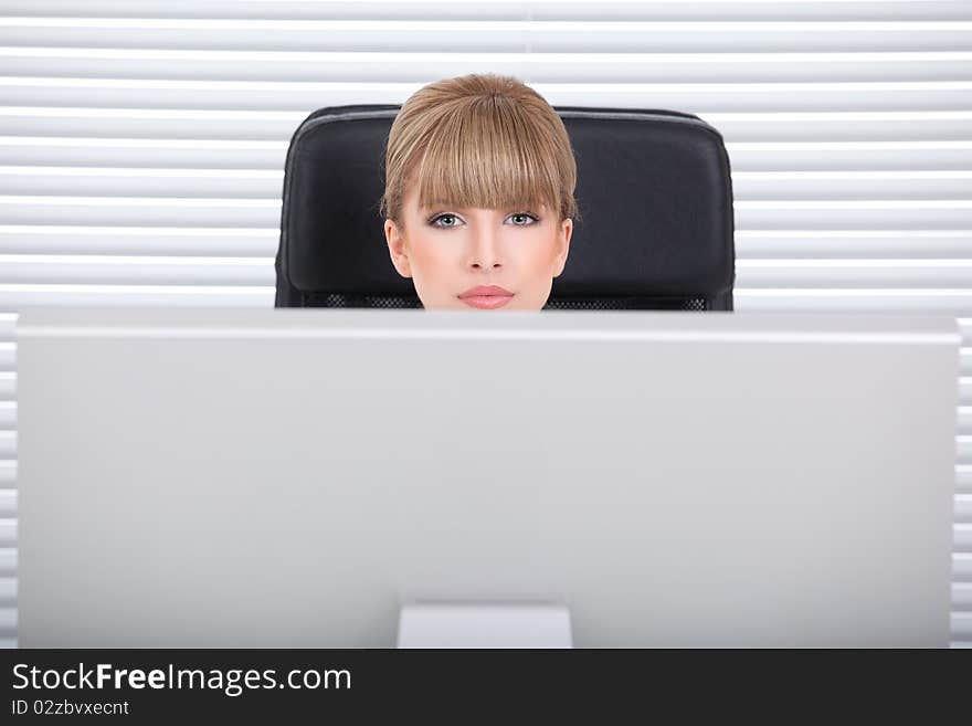 Businesswoman in her office looking over the monitor. Businesswoman in her office looking over the monitor