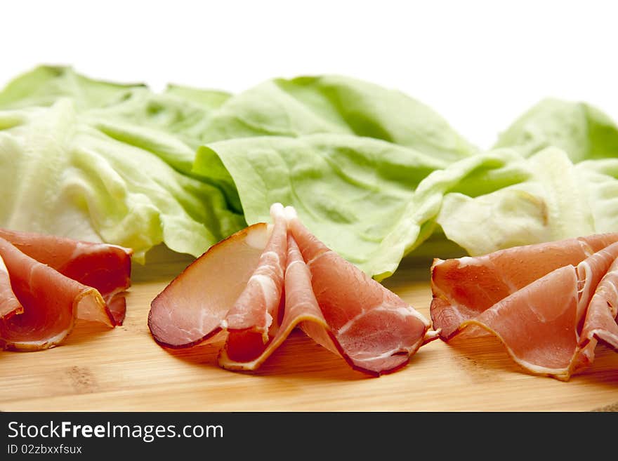 Sausage plate with raw ham and lettuce leaf. Sausage plate with raw ham and lettuce leaf