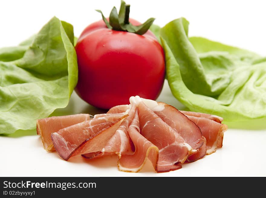 Plate with raw ham and tomato with salad