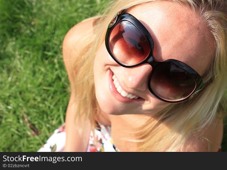 A pretty young woman tilting her head and smiling with glasses on. A pretty young woman tilting her head and smiling with glasses on