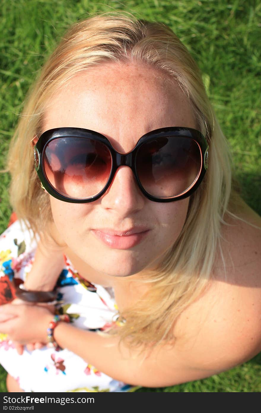 A young beautiful woman with glasses knelt down looking up to the camera. A young beautiful woman with glasses knelt down looking up to the camera