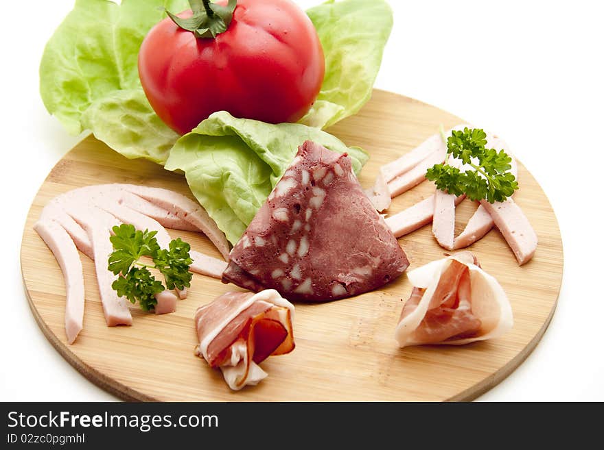 Mixed sausage plate with lettuce leaf and tomato. Mixed sausage plate with lettuce leaf and tomato