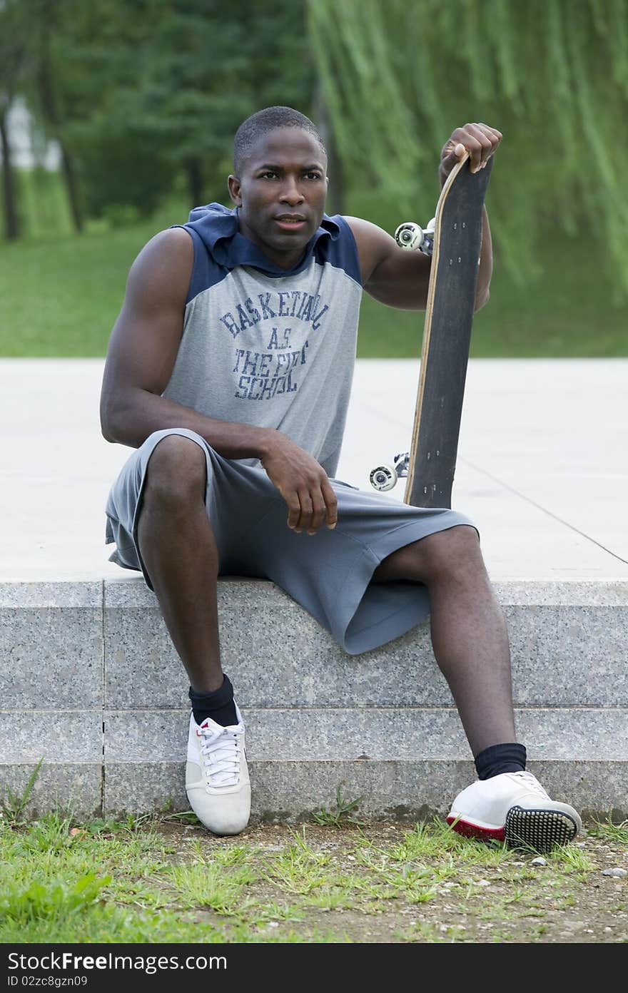 Young man with skateboard in a park