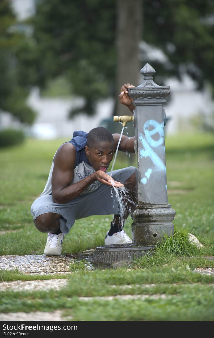 Young man drinking from a fountain. Young man drinking from a fountain