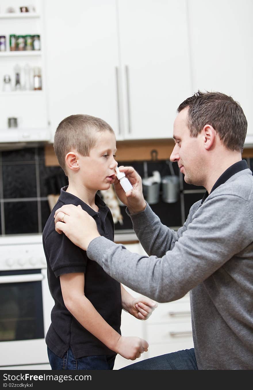 Man giving nose drops to young boy. Man giving nose drops to young boy