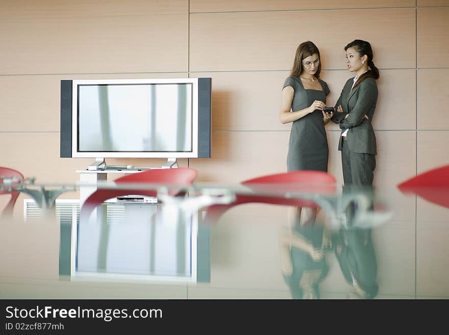 Businesswomen speaking, desk on foreground