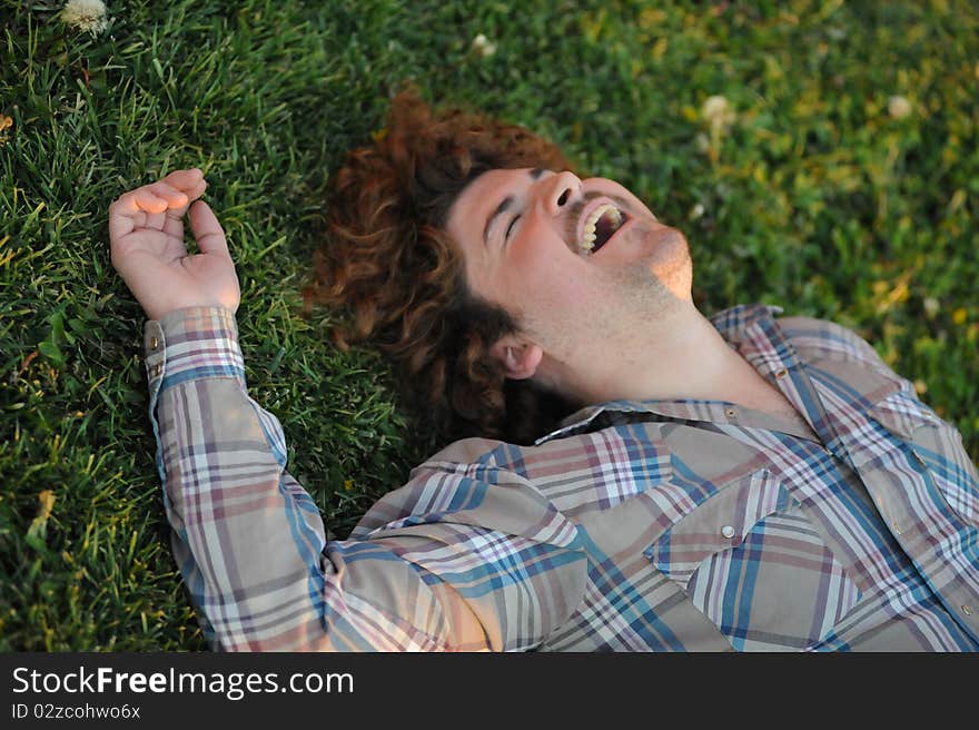 Man smiling and laughing laying on the grass. Man smiling and laughing laying on the grass