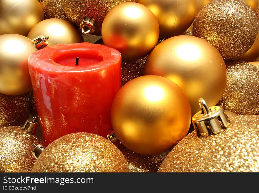 Gold Christmas balls and a red candle