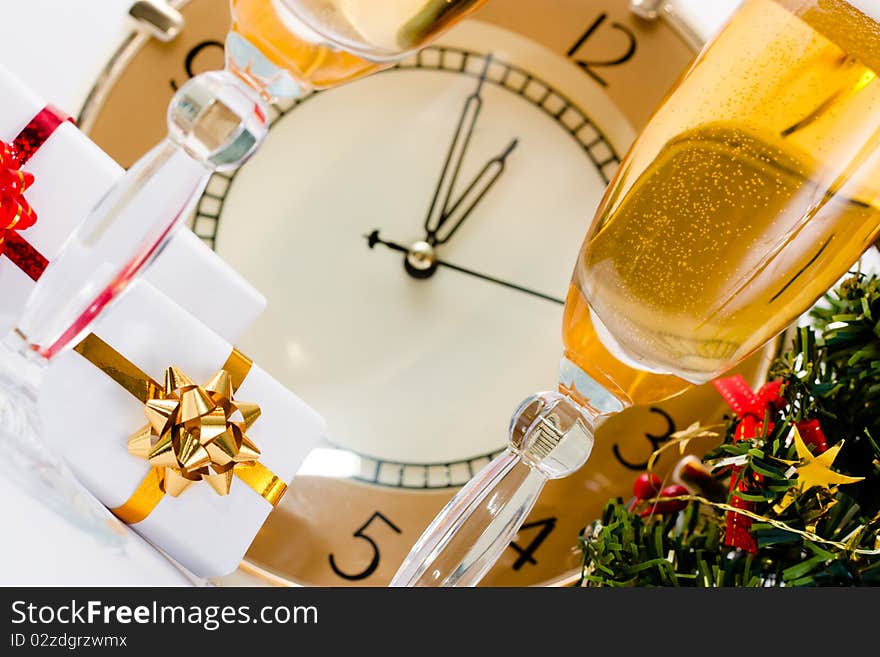 The clock showed almost 12.00 in the Santa hat and gifts champagne. The clock showed almost 12.00 in the Santa hat and gifts champagne