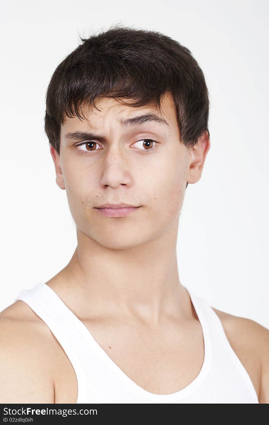 Closeup of a handsome young teenaged guy looking away in thought isolated on white