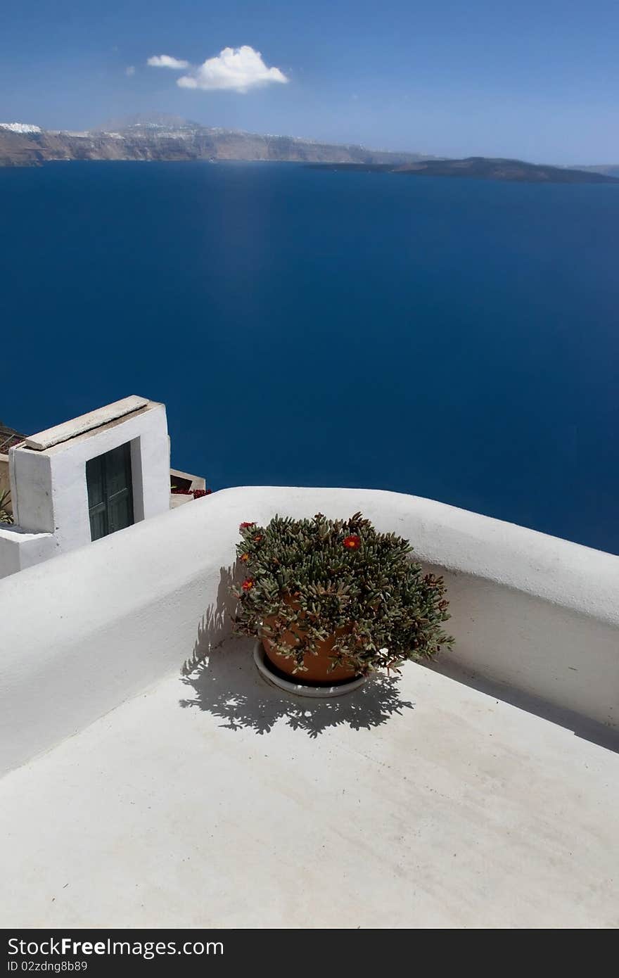 Sea view of the greece island from white terrace with flower pot. Sea view of the greece island from white terrace with flower pot