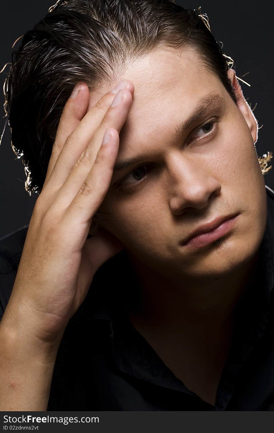 Closeup portrait of a upset young man with hand on his head