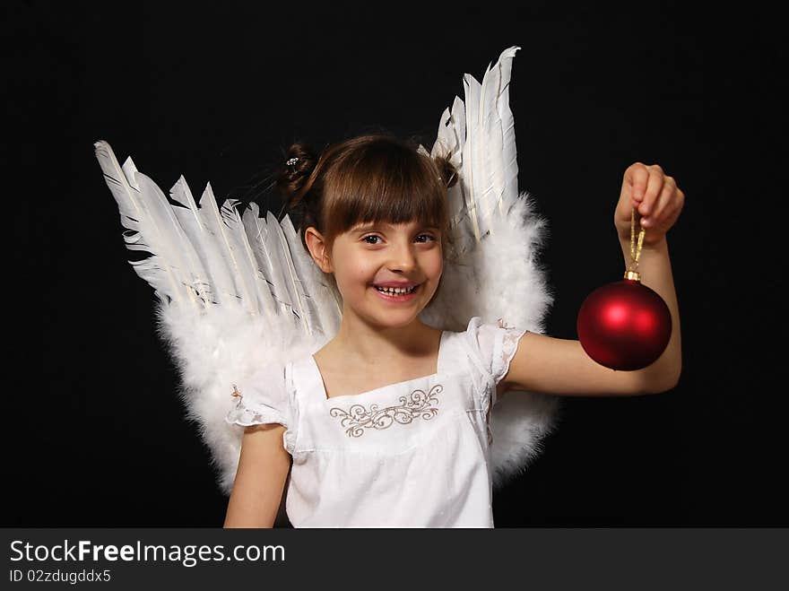 Girl playing with the Christmas glass ball on the black background. Girl playing with the Christmas glass ball on the black background