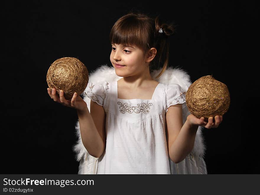 Girl playing with the Christmas glass ball on the black background. Girl playing with the Christmas glass ball on the black background