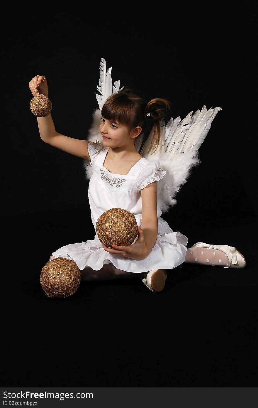 Girl playing with the Christmas glass ball on the black background. Girl playing with the Christmas glass ball on the black background