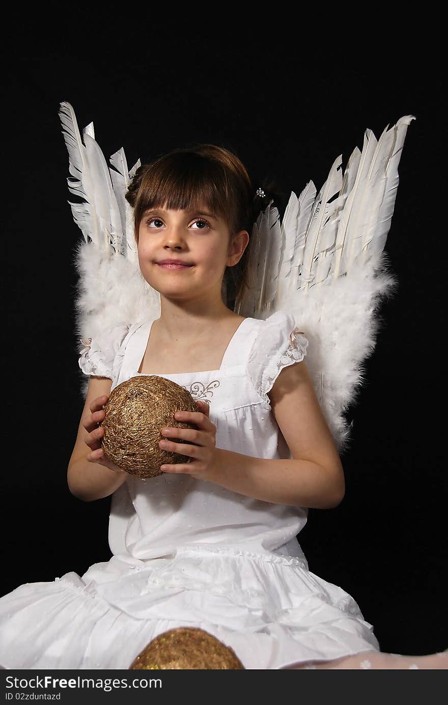 Girl playing with the Christmas glass ball on the black background. Girl playing with the Christmas glass ball on the black background