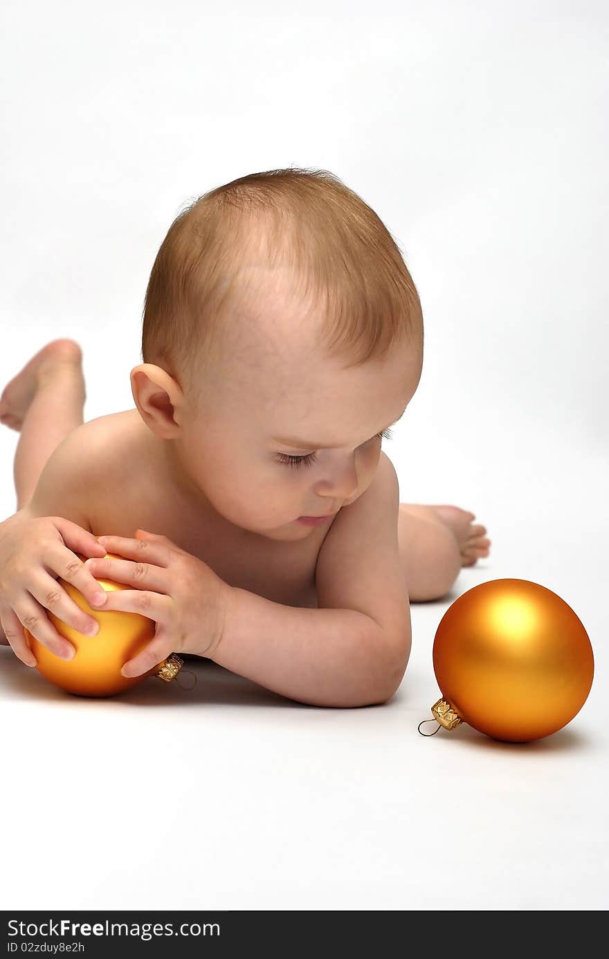 Baby playing with the Christmas glass ball on the white background. Baby playing with the Christmas glass ball on the white background