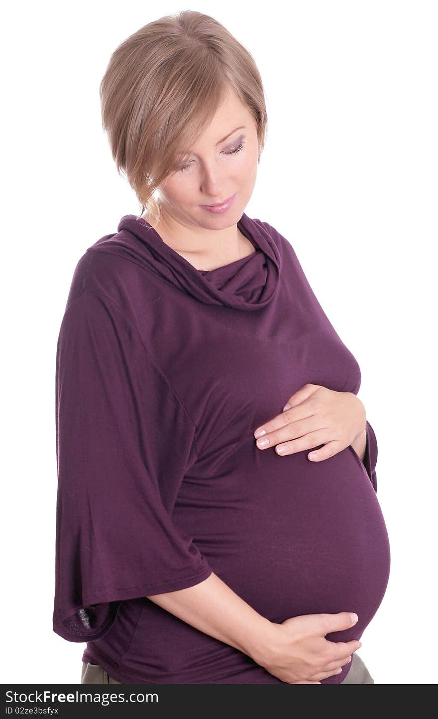 Young pregnant woman in a studio setting isolated over white.