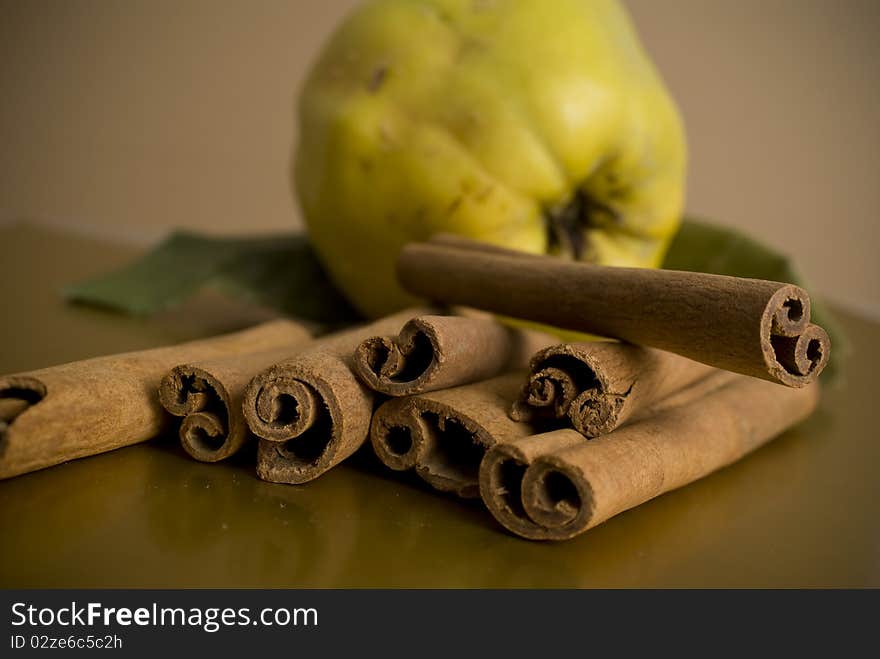 Cinnamon and apples on brown background