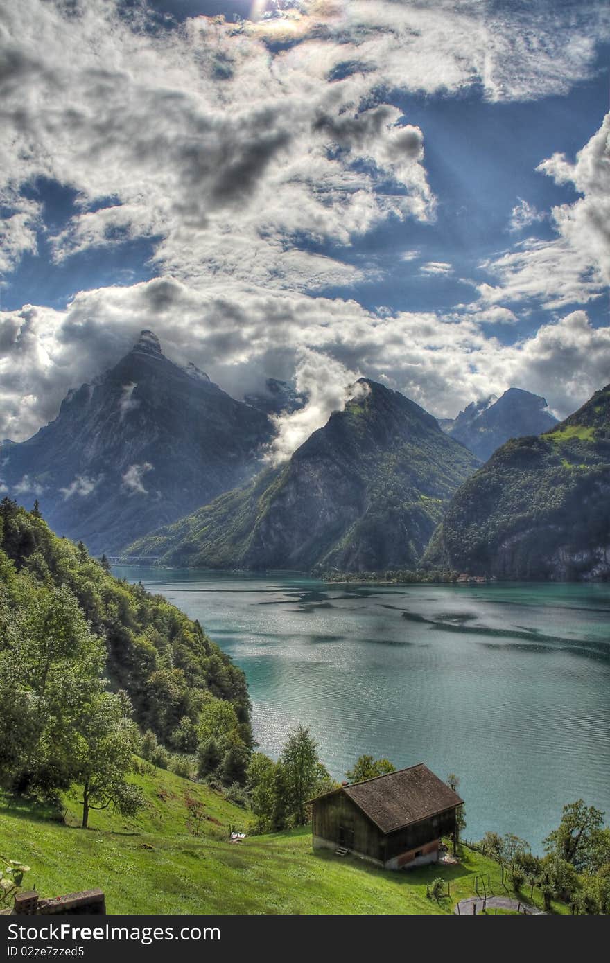 High mountains over the lake and grassy bank. High mountains over the lake and grassy bank