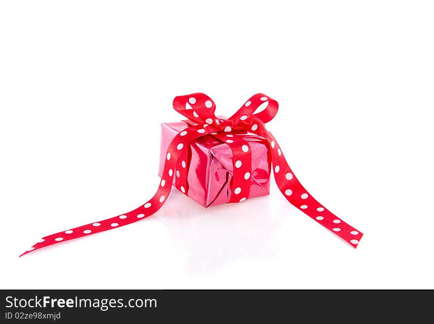 Red gift with a dotted ribbon isolated over white