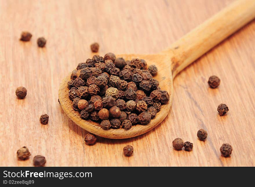 Peppercorns on the table in wooden spoons. Peppercorns on the table in wooden spoons