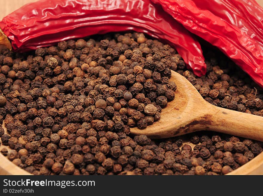 Peppercorns on the table in a wooden bowl. Peppercorns on the table in a wooden bowl