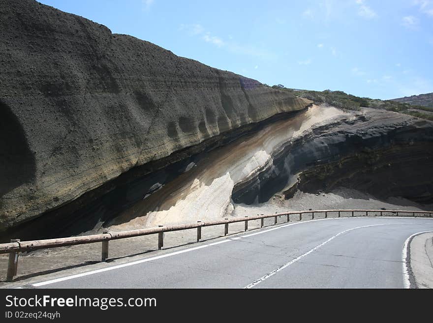 Ash deposits layered over time as different volcanic eruptions took place in the Canary Islands, Tenerife (Teide is the volcano that is responsable for that).