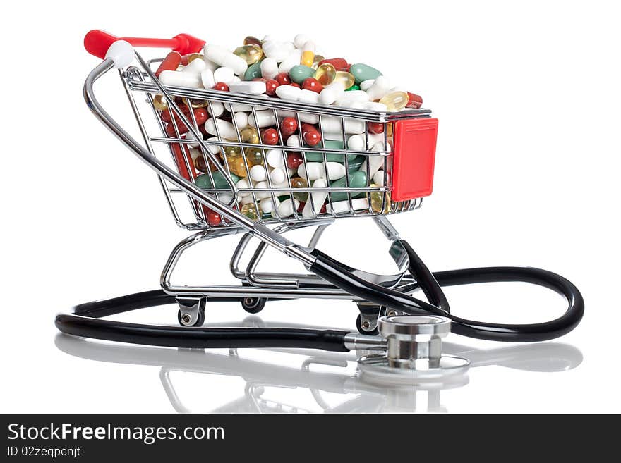 Shopping cart full with pills/capsules and a stethoscope on a white background. Shopping cart full with pills/capsules and a stethoscope on a white background