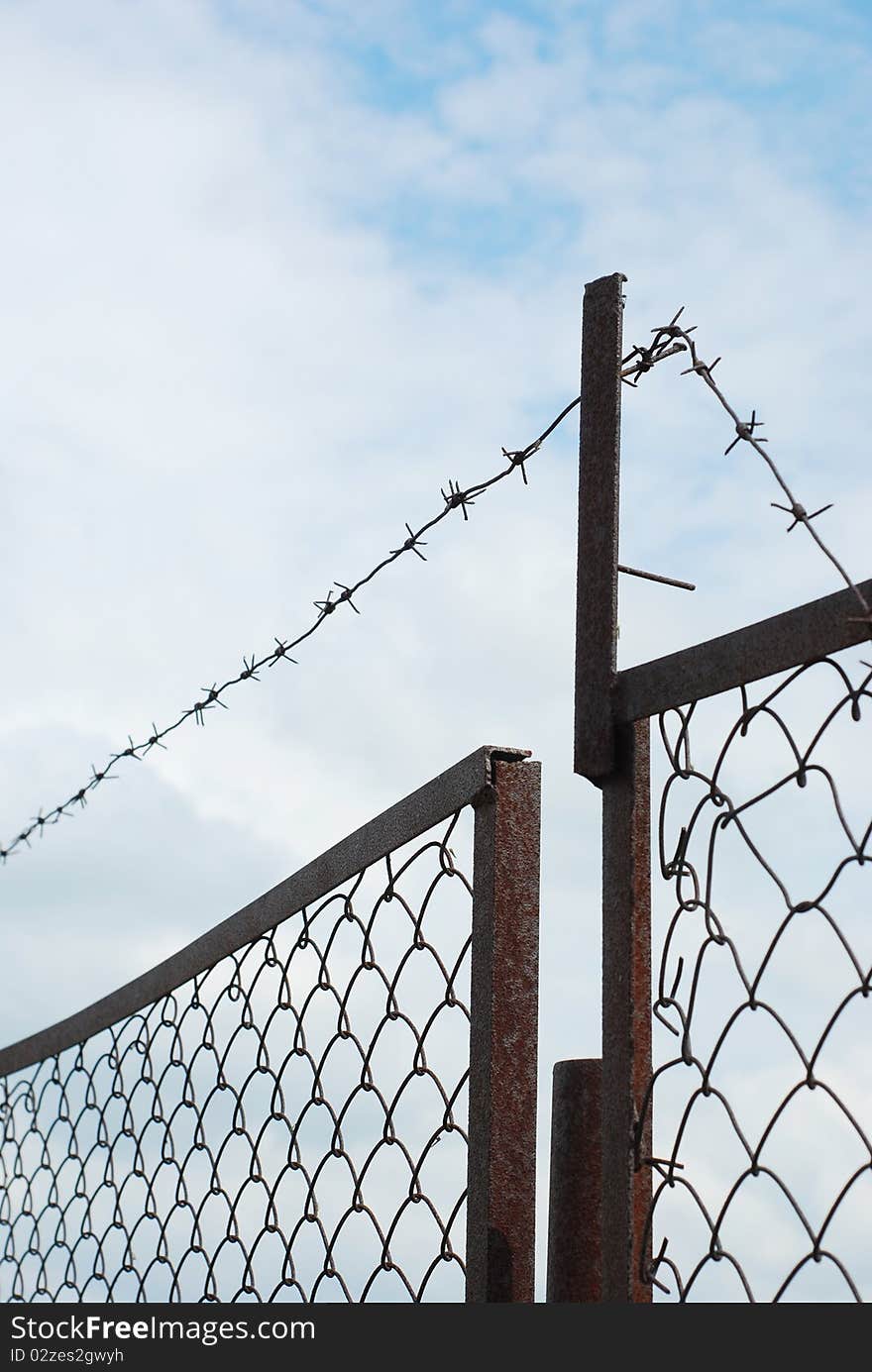 Rusty fence with barbed wire. Rusty fence with barbed wire