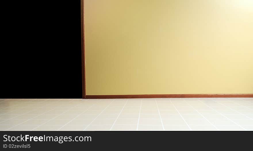 Empty room with a linoleum floor with a yellow painted wall