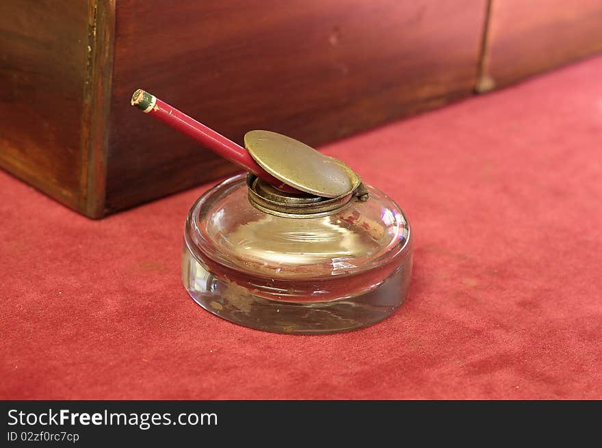 A glass pencil holder on a table