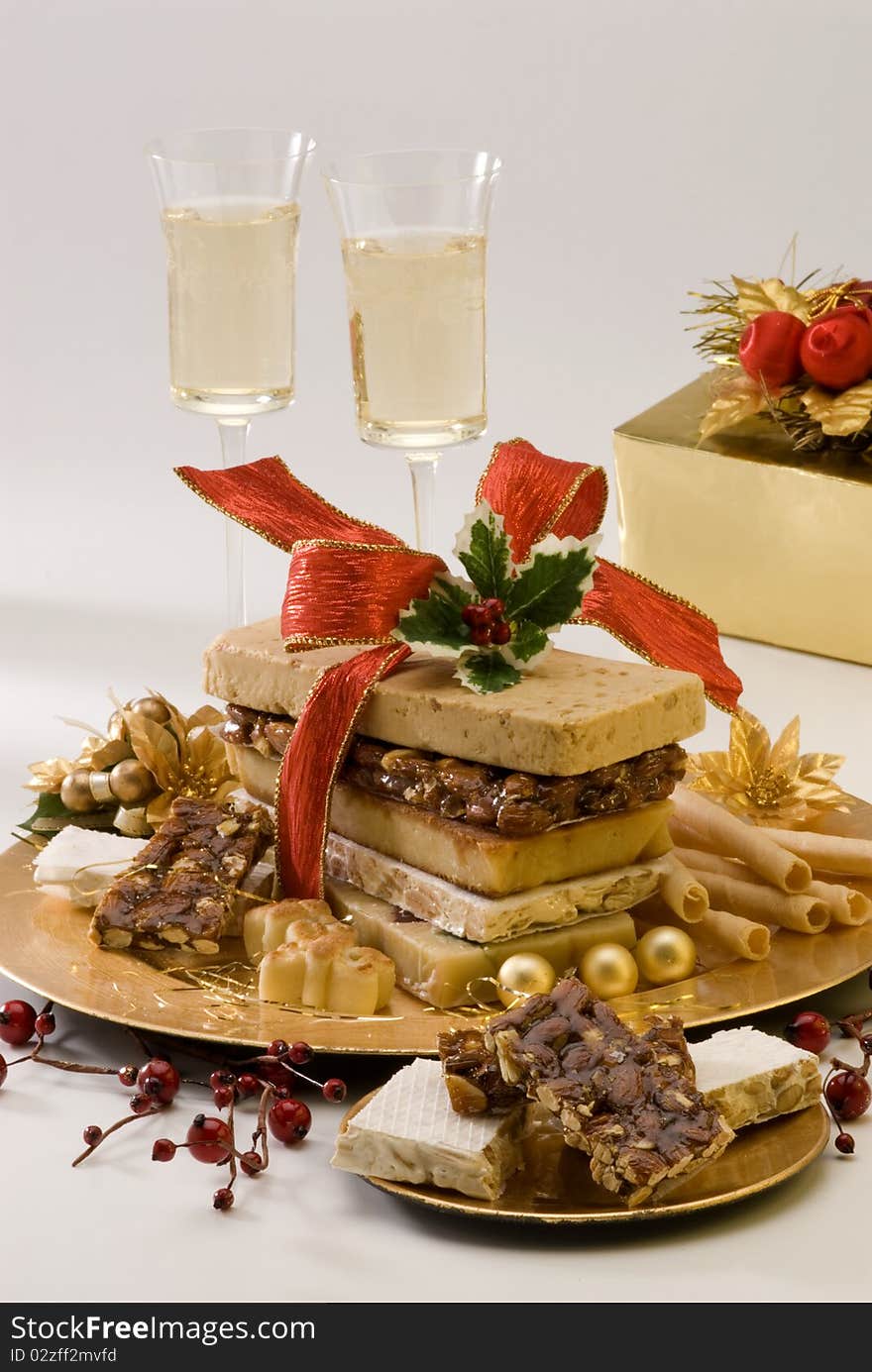 Typical Spanish Christmas nougat in a golden plate. White background.