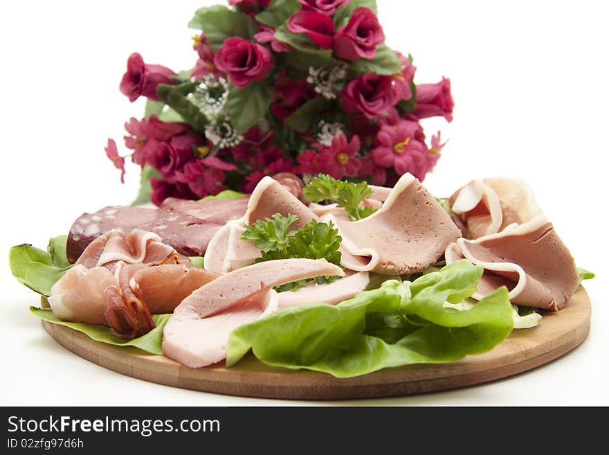 Sausage plate with salad and bunch of flowers. Sausage plate with salad and bunch of flowers