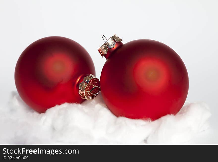 Two red Chrismas baubles in the snow