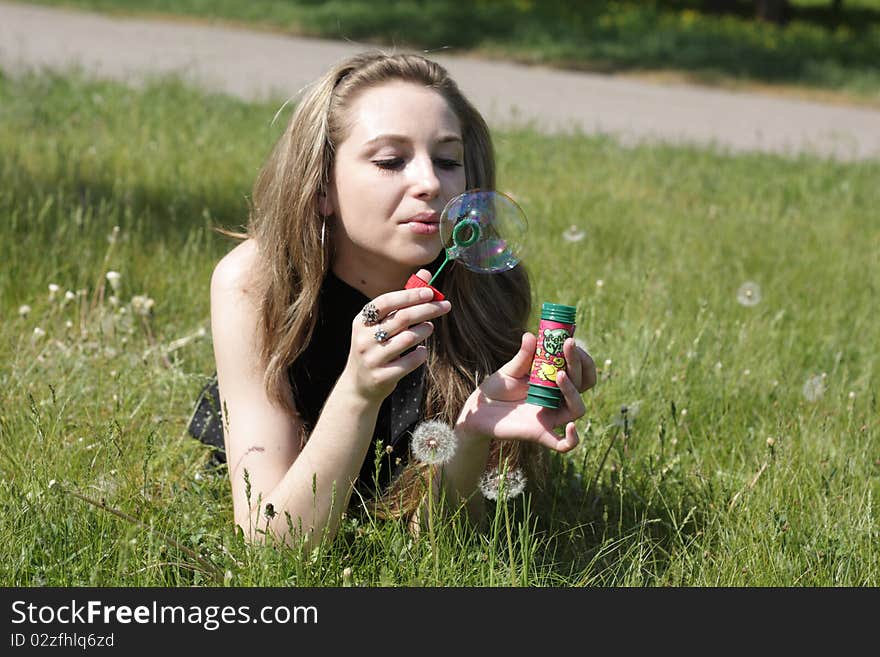 Young women lying on green grass in dandelions. Young women lying on green grass in dandelions