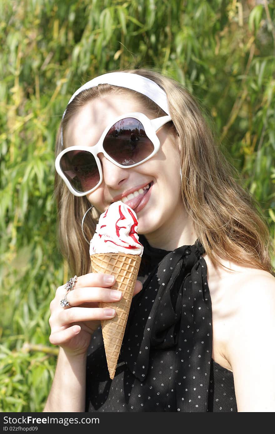 A young pretty teenage girl with ice cream cone outside