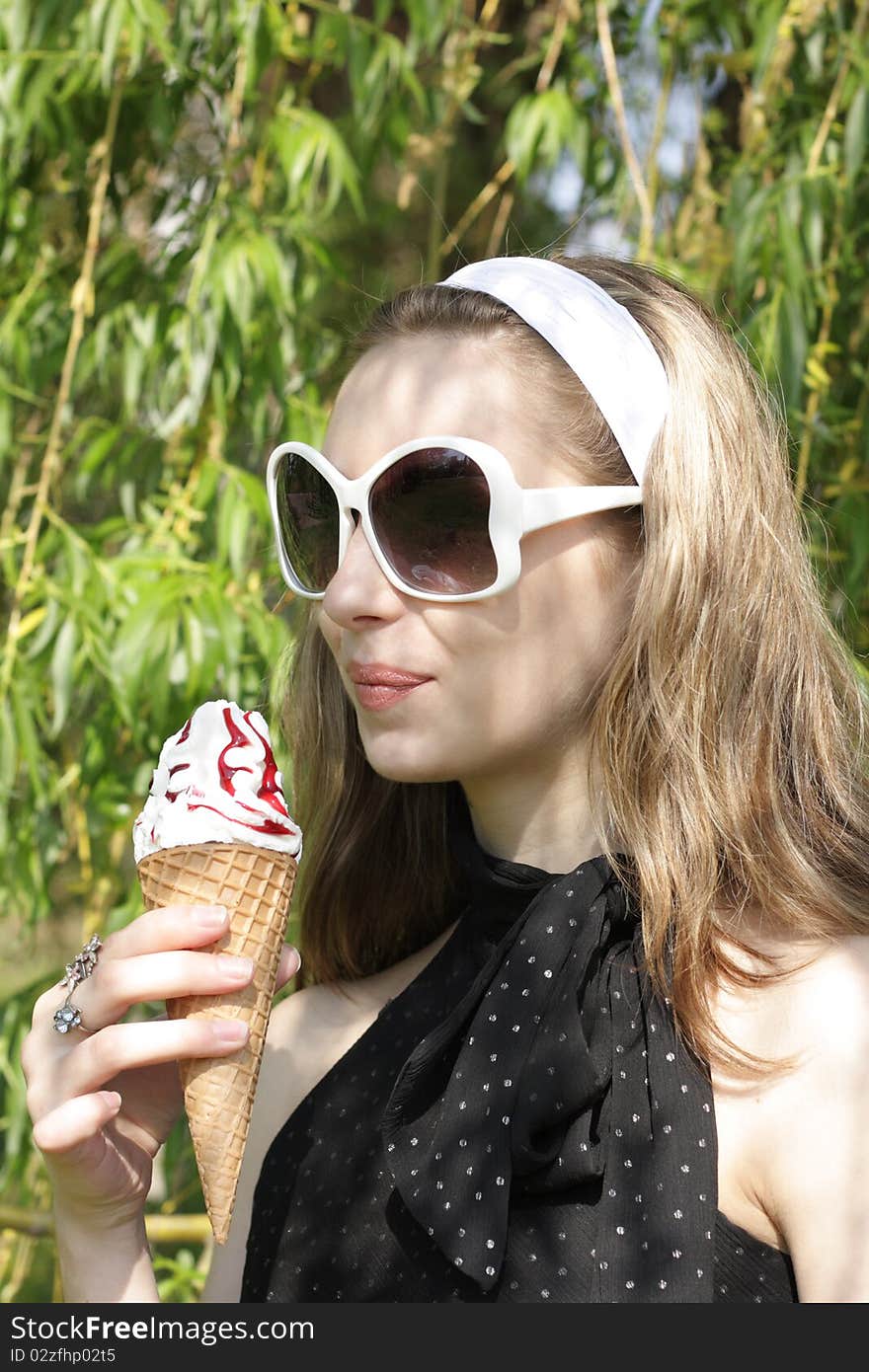 A young pretty teenage girl with ice cream cone outside