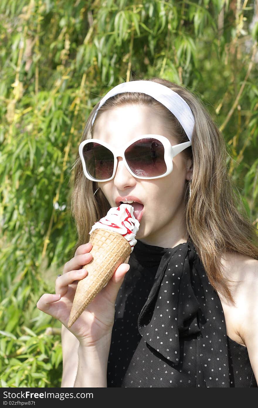 A young pretty teenage girl with ice cream cone outside