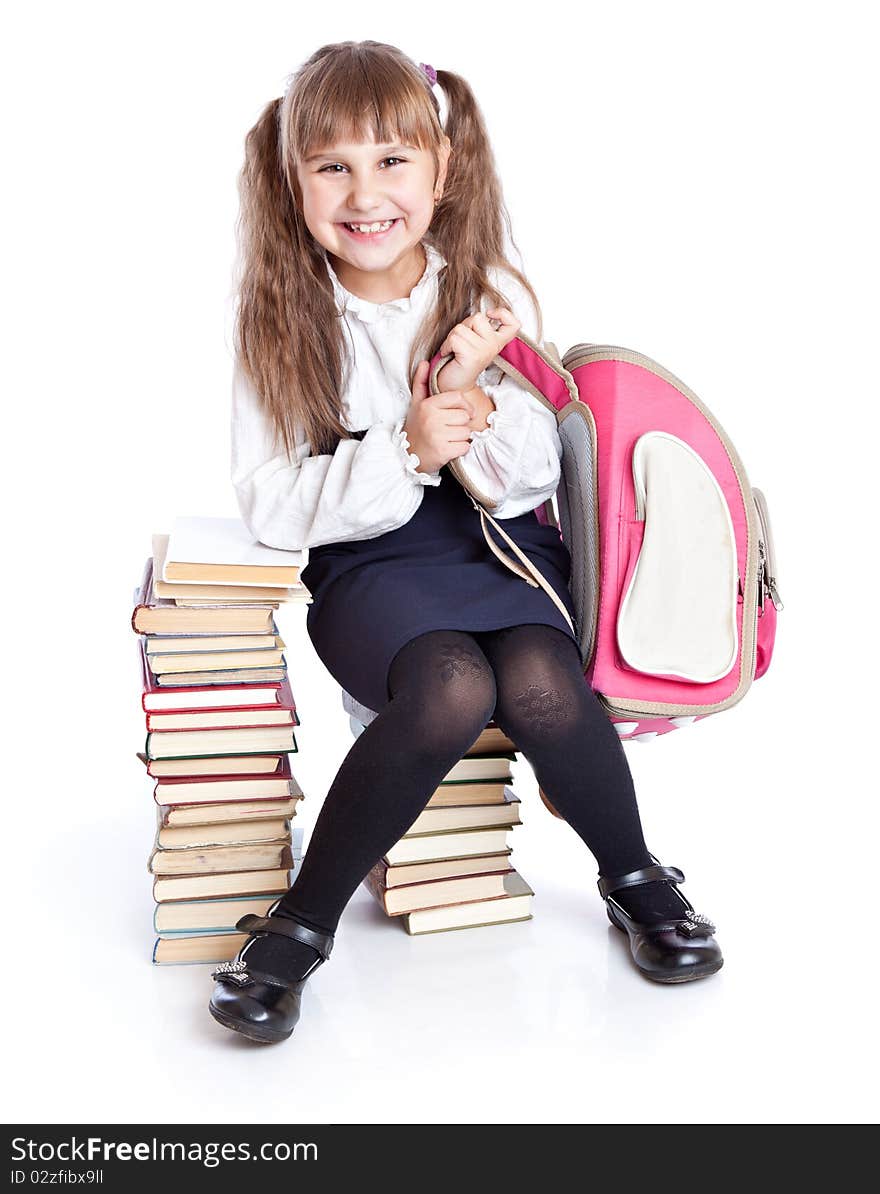 A little smiling girl is sitting on the books. A little smiling girl is sitting on the books