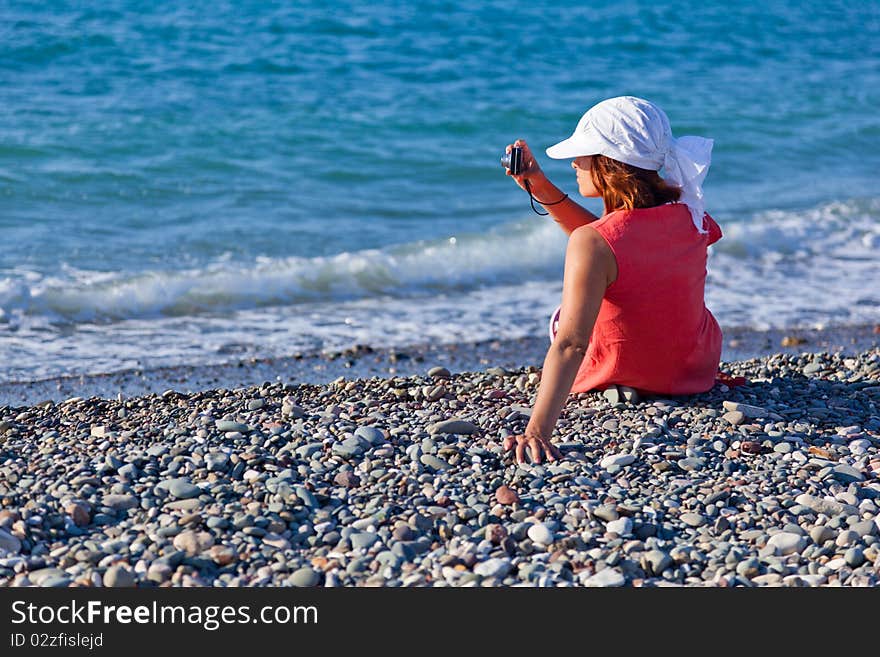 A woman with a camera on the coast