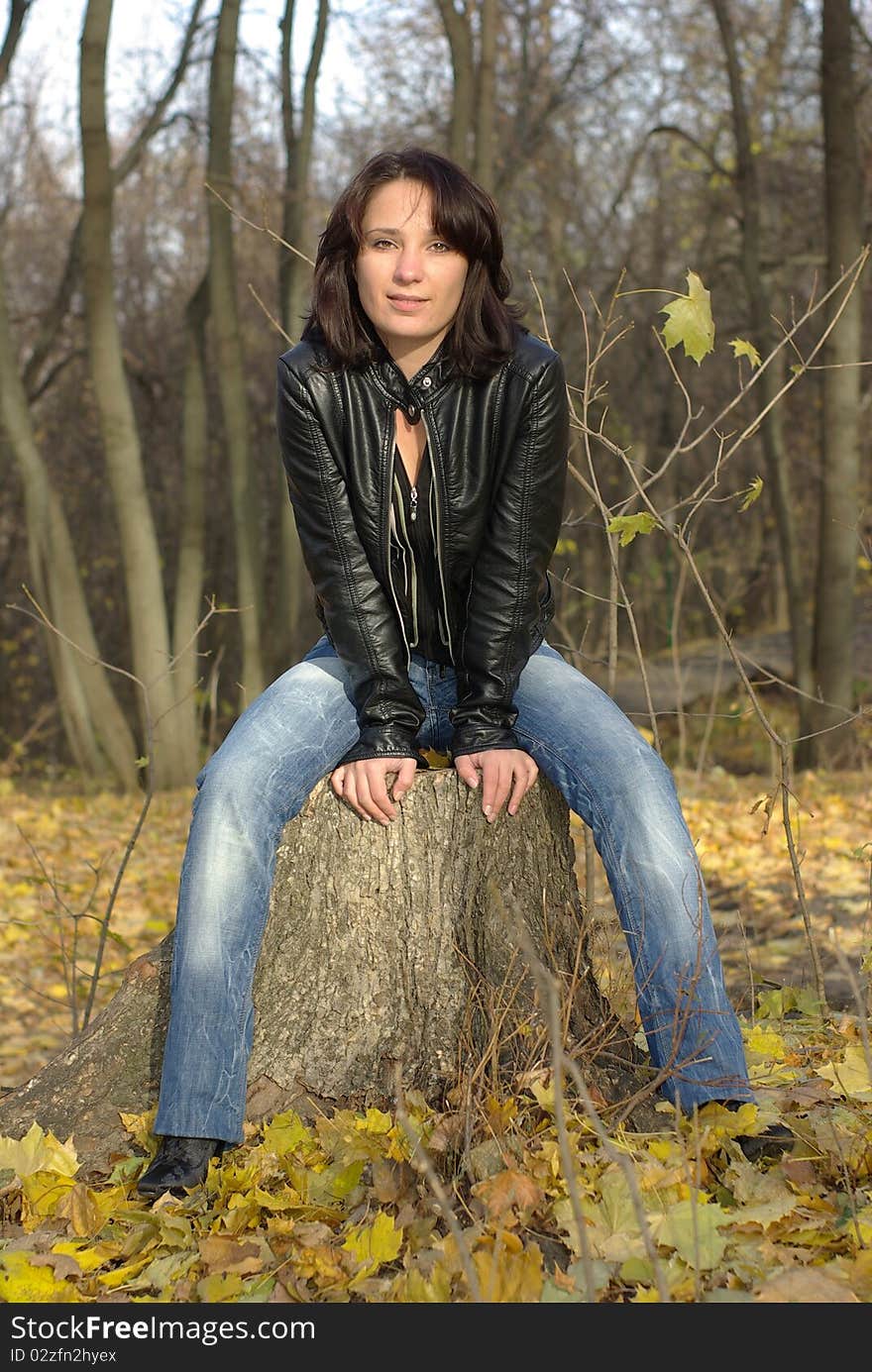 Girl sitting on a tree stump. Girl sitting on a tree stump