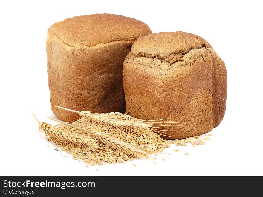 Homemade whole bread and stalks of wheat on a white background. Homemade whole bread and stalks of wheat on a white background