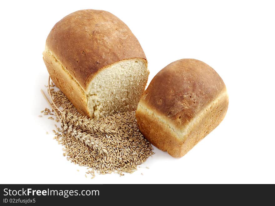 Homemade bread and stalks of wheat on a white background