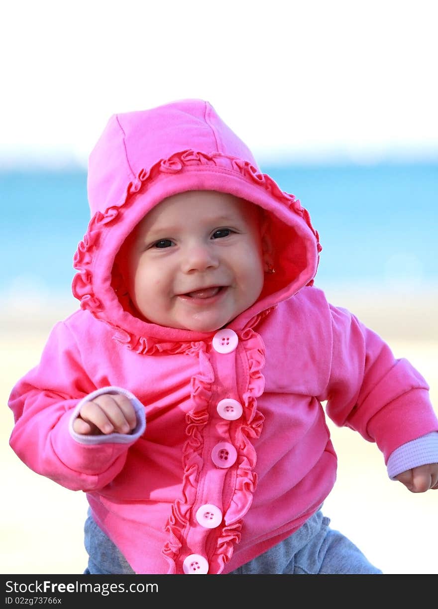 Happy baby girl with pink jacket smiling. Happy baby girl with pink jacket smiling