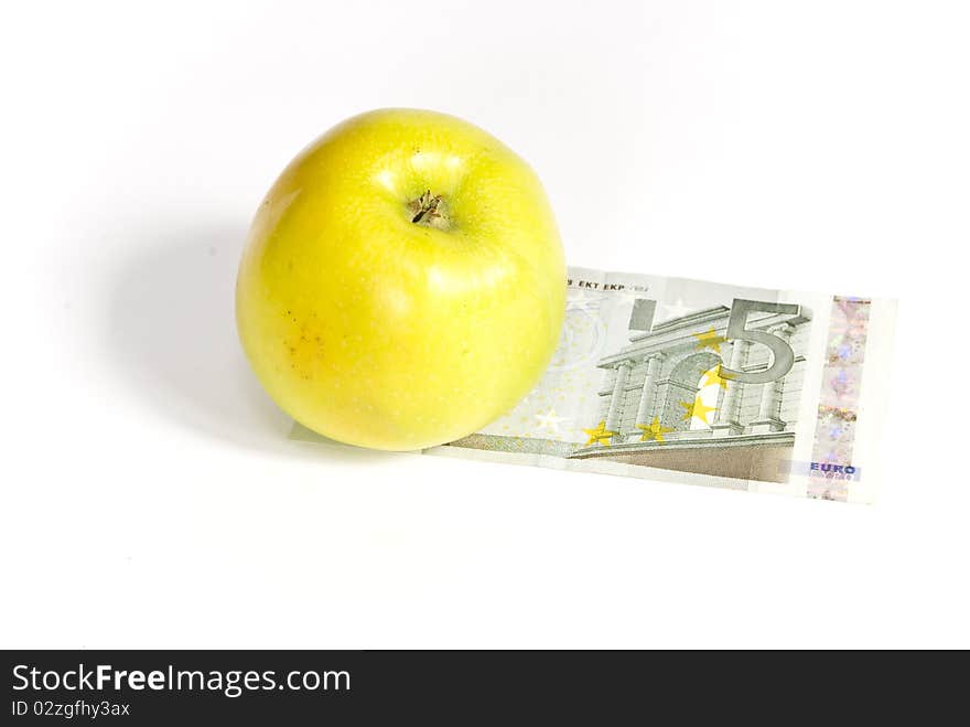 Green apple lying on the banknote, on a white background. Green apple lying on the banknote, on a white background