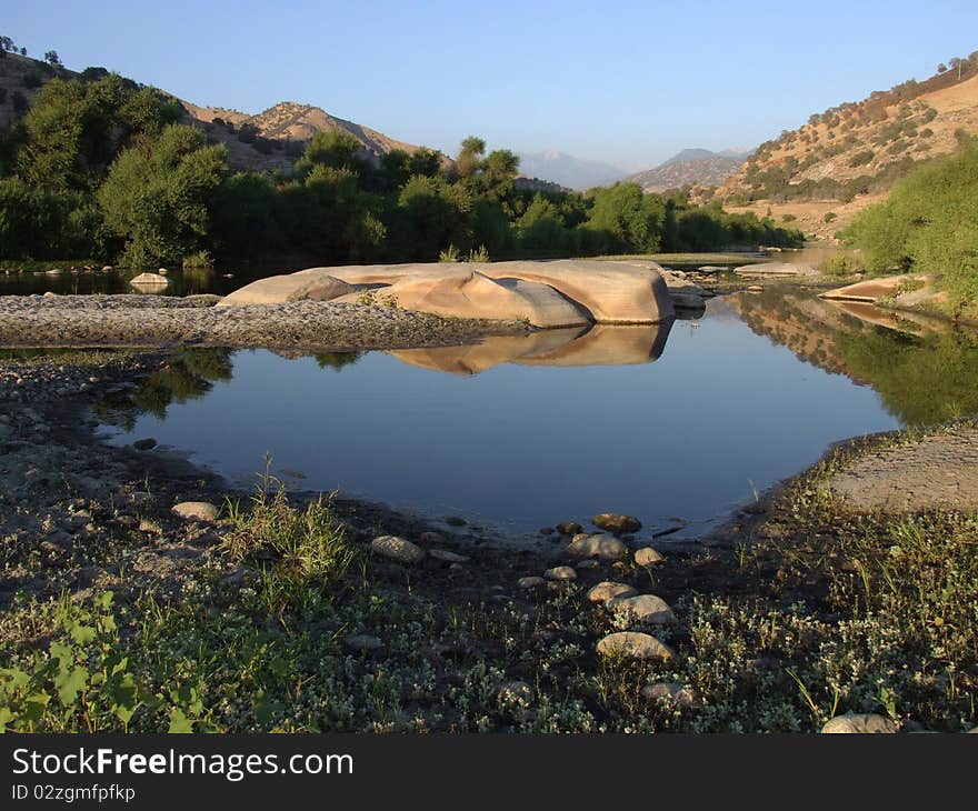 Little pond in Sierra Nevada with reflections of sky and rocks located near the town Three Rivers, California, US. Little pond in Sierra Nevada with reflections of sky and rocks located near the town Three Rivers, California, US